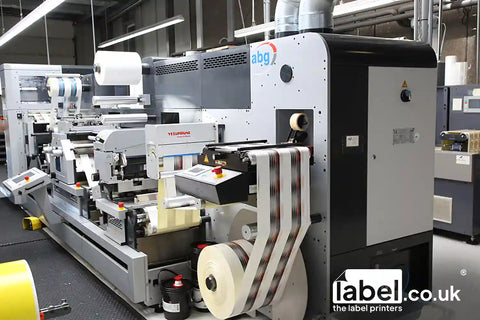honeystickers partner Label printing machine with 'label.co.uk' branding in a factory setting